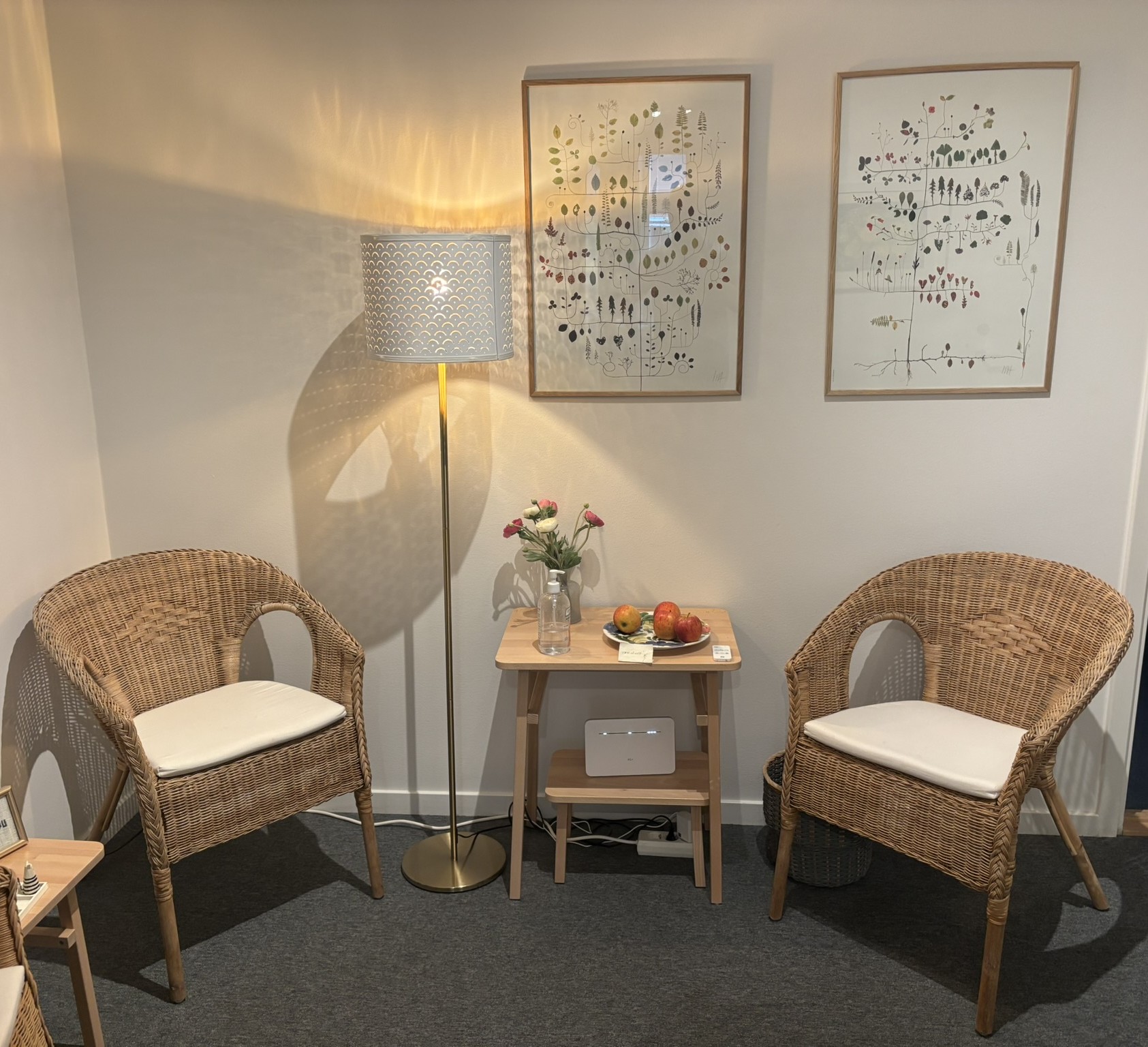 Väntrummet med rottingfåtöljer och botaniska tryck
